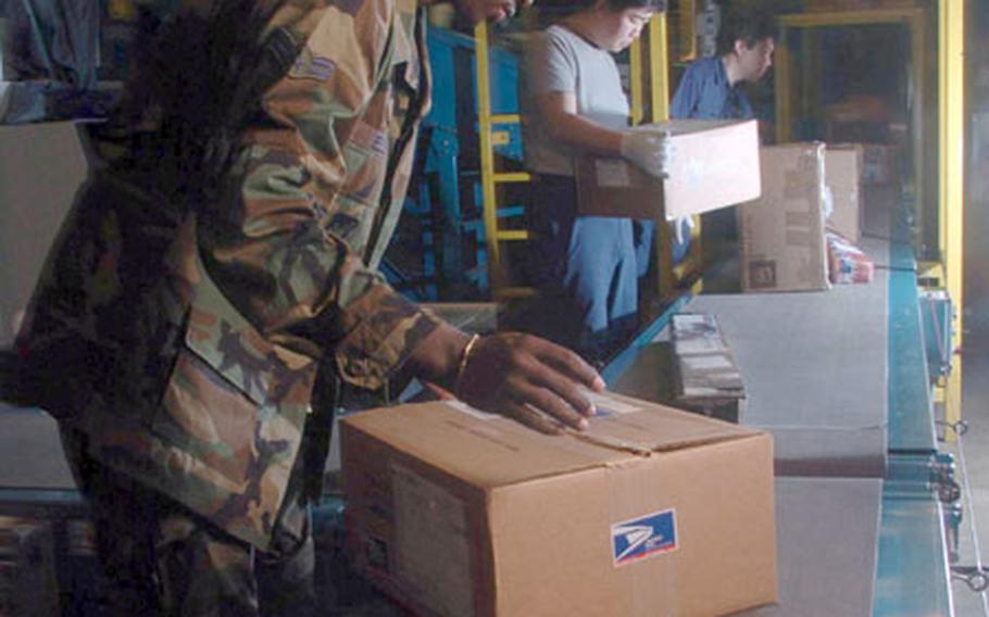 Airman 1st Class Jonathon Elzie from Detachment 2, Air Postal Squadron at Yokota Air Base, Japan, along with Japanese employees inspects packages at the mail processing facility here for the proper markings before shipment.