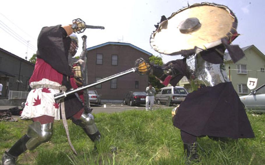 Mark Iacampo, on the left, as "Lord Codogan," duels in a medieval combat with rattan swords against Yuji Okada as "Lord Raven."