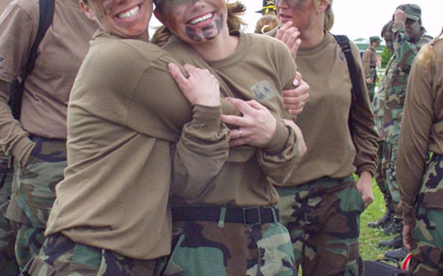 Julie Murray, left, and Adrianne Thrailkill, members of the Homefront Honeys team from the 1/4 Cavalry&#39;s Troop A, grab a hug while surrounded by teammates during a break in Saturday&#39;s Ladies Spur Ride. The event, for wives of soldiers in the 1/4 Cavalry and other 1st Infantry Division units based in Schweinfurt, Germany, was a scaled-down version of the daylong test of soldiering skills through which cavalry troopers earn their spurs.