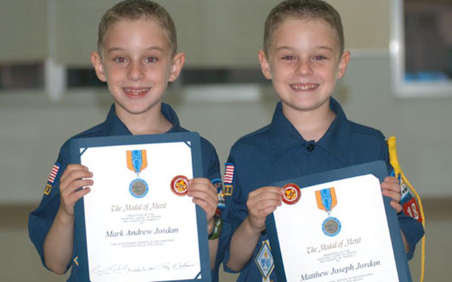 Mark Jordan, left, and twin brother Matthew Jordan received the Medal of Merit from the Boy Scouts of America Tuesday for saving the life of 8-year-old Nicky Cullen last year at Misawa Air Base, Japan.