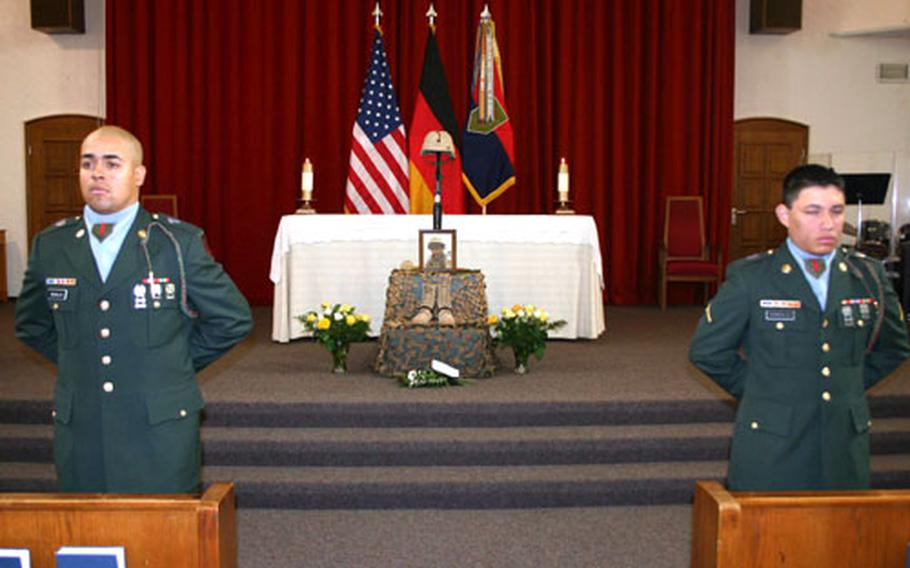 Pfc. Daniel Medeles of Troop C, 1st Squadron, 4th Cavalry, left, and Pvt. Ronald Gonzalez, Headquarters and Headquarters Troop, 1st Squadron, 4th Cavalry, stand before a memorial display for Spc. Michael Campbell in Schweinfurt, Germany, on Wednesday.