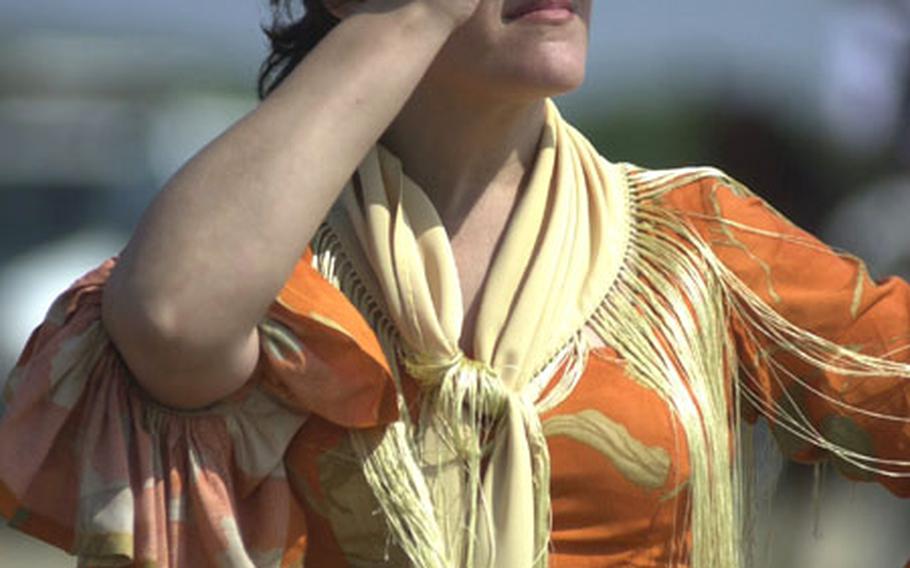 A Spanish woman in a traditional gypsy dress on Wednesday watches horses and carts unload from a ferry boat onto the coast of Donana National Park near Sanlúcar de Barrameda, Spain. More than 1 million people are expected to make the pilgrimage to the city of El Rocío this week. It is Spain&#39;s largest Catholic pilgrimage.