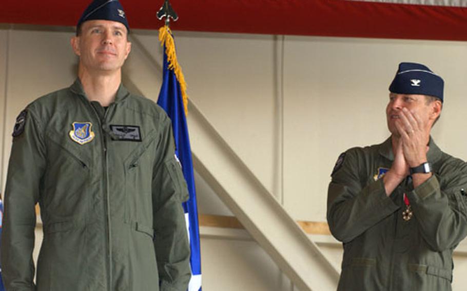 Air Force Col. William W. Uhle Jr., left, is prsented as new commander of the 8th Fighter Wing at Kunsan Air Base during ceremony there Thursday morning. At right of photo is Col. Robin Rand, who until Thursday commanded the wing for the past year.