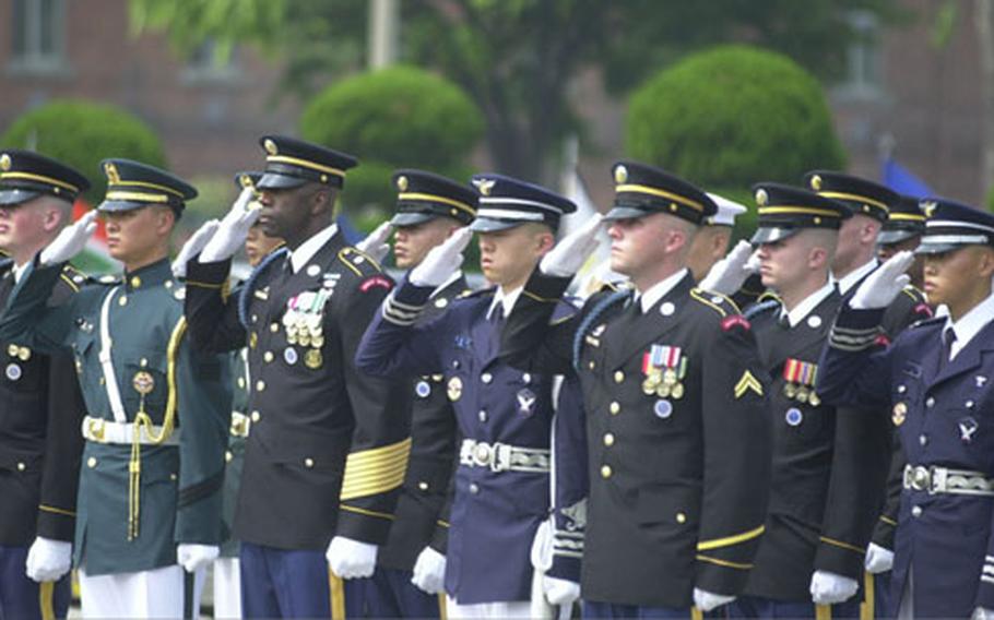 Members of an honor guard salute as taps is played during a Yongsan Garrison repatriation ceremony Thursday. Eighteen sets of remains thought to be those of American soldiers killed in the Korean War were honored.