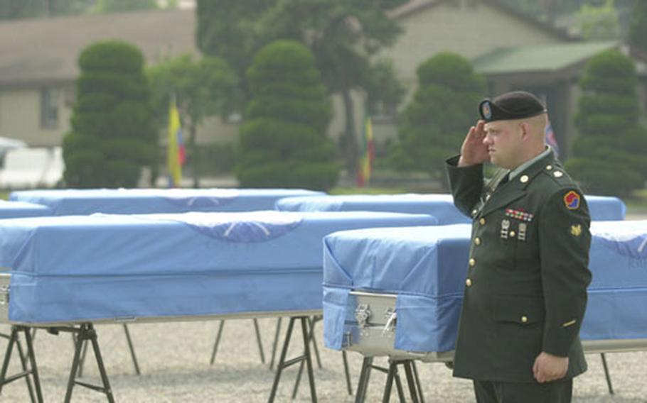 Before a repatriation ceremony Thursday at Yongsan Garrison, a lone American soldier stands and salutes in front of metal coffins carrying remains thought to be those of U.S. soldiers killed in the Korean War.