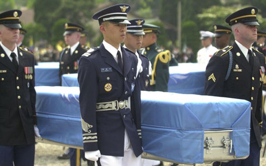 An honor guard carries a casket containing remains thought to be those of an American soldier killed during the Korean War. Eighteen sets of remains were repatriated Thursday at a Yongsan Garrison ceremony.