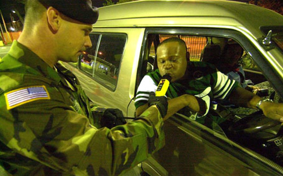 Sgt. Joseph Chestnut of the 88th Military Police Detachment gives Maj. Randall Cephus a sobriety check with a passive alcohol device at checkpoint in Sagamihara Family Housing Area.