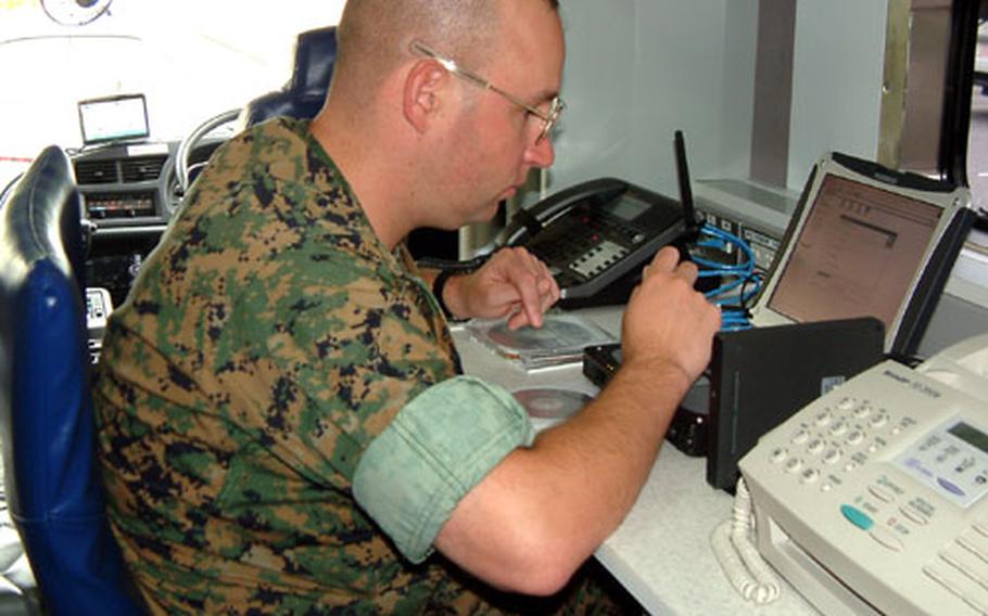 Marine Staff Sgt. Michael Abballe programs a new computer at a workstation in the Marines&#39; new $450,000 mobile comand post on Camp Foster. The vehicle is one of two purchased for Marine bases in Japan. Thirteen others are being provided for Marine bases in the U.S.
