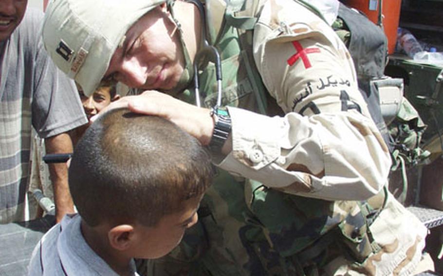 Capt. Kevin Burnham, a physician&#39;s assistant with the 2/7 Cavalry Regiment, examines an Iraqi boy&#39;s ear during a goodwill visit Friday to Mushada, Iraq, a village 30 miles north of Baghdad.