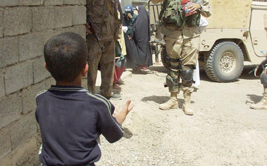 An Iraqi boy plays catch with 2nd Lt. Francis McCahill of Melbourne, Fla., a medical platoon leader with the 2-7 Cavalry Headquarters Headquarters Company during a trip to Mushada, Iraq, to provide medical checkups and medicine to residents.