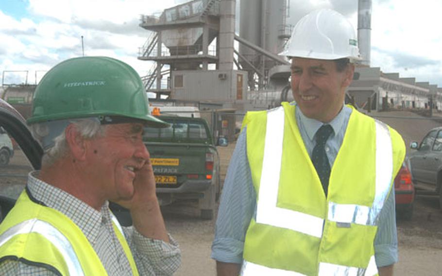 Neil Smith, left, general foreman, and Tim Eden, project manager, chat Friday about the runway reconstruction project at RAF Mildenhall, England, in the shadow of a temporary plant built to mix the tons of concrete needed for the project.