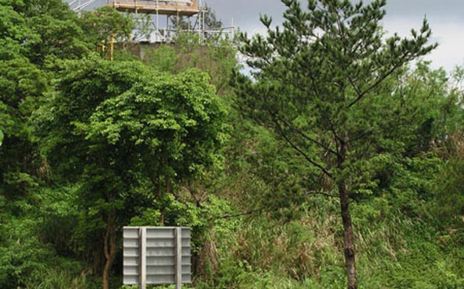 An observation tower sits atop a water tank in Igei community in Kin. Residents erected the tower in a protest against a new U.S. Army urban combat training complex planned at Range 4 on Camp Hansen. The observation tower overlooks the training area on the farther side of the Okinawa Expressway.