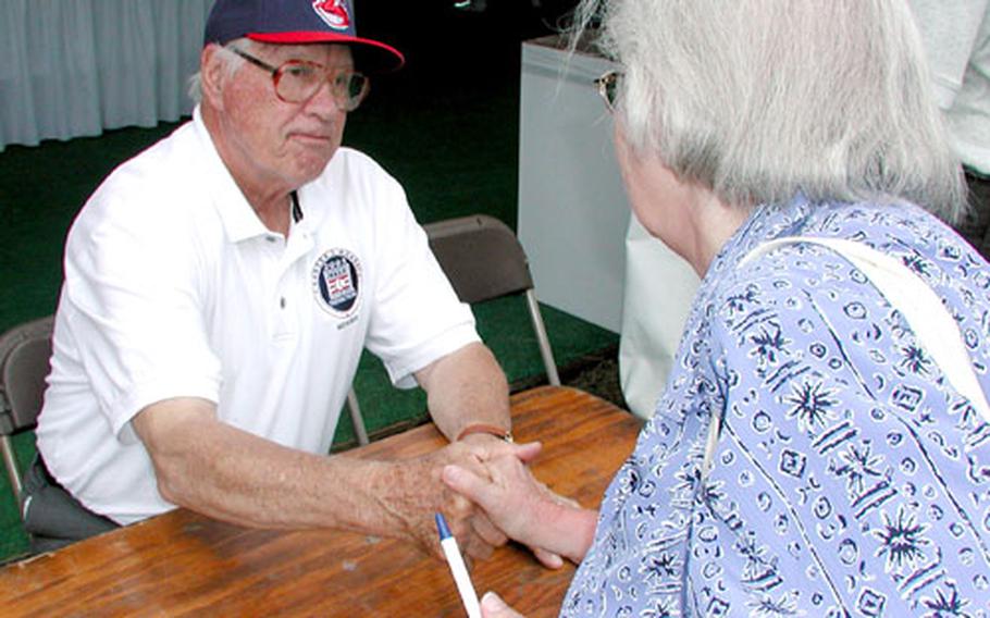 Baseball Hall of Famer Bob Feller greets a fan during an autograph session Sunday at the National World War II Reunion in Washington. Feller, former major leaguer Monte Irvin and Negro League player Buck O&#39;Neil — all World War II veterans — were panelists at a discussion on veterans as baseball players.
