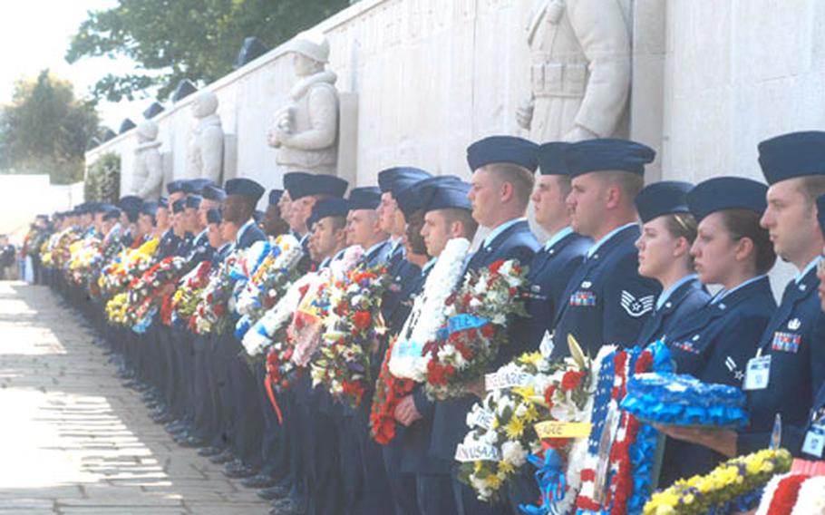 Active duty Air Force members stationed in England hold wreaths to be placed at the Cambridge American Cemetery in Madingley, England. More than 2,000 people attended the ceremony Monday.