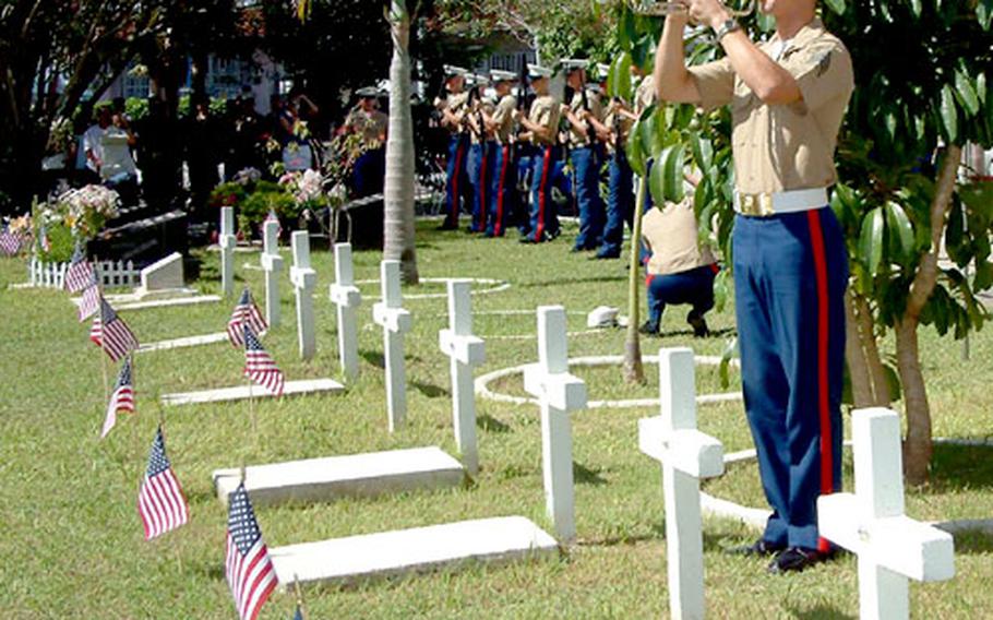 A Marine bugler plays "Taps" during a Memorial Day observance Monday at the International Cemetery in Naha, Okinawa. More than 200 people attended the service at a graveyard that was set aside 150 years ago for U.S. citizens in a pact between U.S. Navy Commodore Matthew Perry and the Kingdom of the Ryukyus.