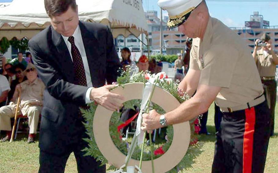U.S. Consul General Thomas Reich and Brig. Gen. Frank A. Panter present a wreath during Monday&#39;s Memorial Day service at the International Cemetery in Naha.