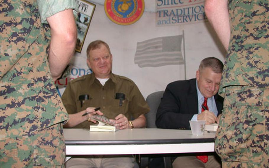 Retired Marine Gen. Anthony Zinni, right, former commander of U.S. Central Command, signs copies of his new book, "Battle Ready," written with renowned author Tom Clancy, left, outside Marine Corps Base Quantico, Va. "Battle Ready" is about Zinni&#39;s 40-year career within the Marine Corps and then at the State Department as a special envoy.