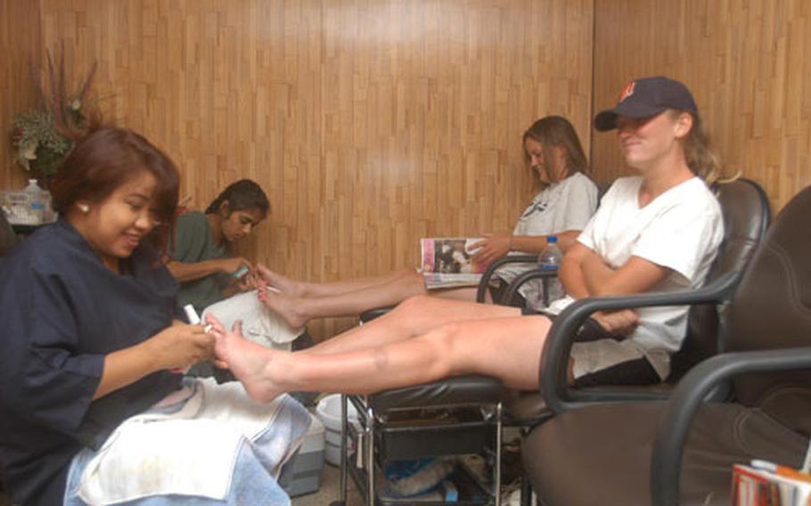 Spc. Christy Gunther, near wall, and Spc. Shelly Gruener, both truck drivers from the 1742nd Transportation Company get a pedicure from Nisha Jamal Deen and Margi Bangog.