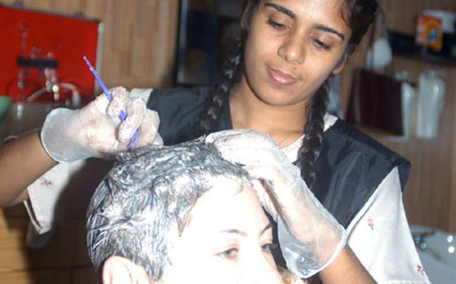 Spc. Lynda Youngs, of the 1836th Transportation Company, tries to lighten her hair for a dramatic change. Nisha Jamal Deen, a beautician of five years, has some problems getting Youngs hair to lighten to an ash blonde, but she doesn&#39;t give up trying.