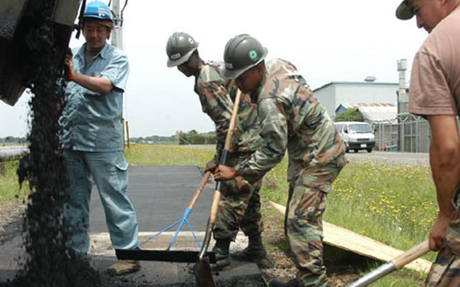 From left, a Japanese construction worker dispenses hot tar as Constructionman Cedric Park, Petty Officer 3rd Class Arlo Capelle and Petty Officer 2nd Class Paul Torres from Naval Mobile Construction Battalion 5 Detail Atsugi, use shovels and rakes to lay asphalt for a flight line running track Thursday at Atsugi Naval Air Facility, Atsugi. The Seabee detail is permanently based at Port Hueneme, Calif.