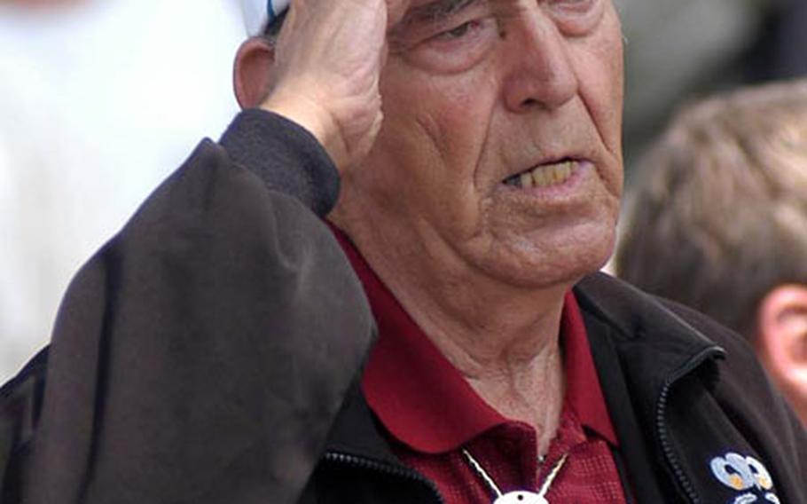 Arthur M. Peterson, a 101st Airborne Division D-Day veteran salutes as he sings the national anthem following a parachute drop on the outskirts of Ste. Mere-Eglise, France, on Saturday. More than 600 soldiers from the 101st, 82nd Airborne Division and the 173rd Airborne Brigade jumped from U.S. Air Force C-130 and C-17 airplanes.