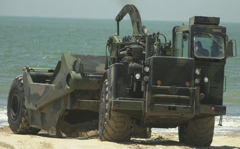 A U.S. Navy scraper from Naval Mobile Construction Battalion 74 smooths out the beach in Valdegrana, Spain, on Thursday. Navy Seabees deployed to Naval Station Rota are repairing the beaches near the Navy base in a goodwill project.