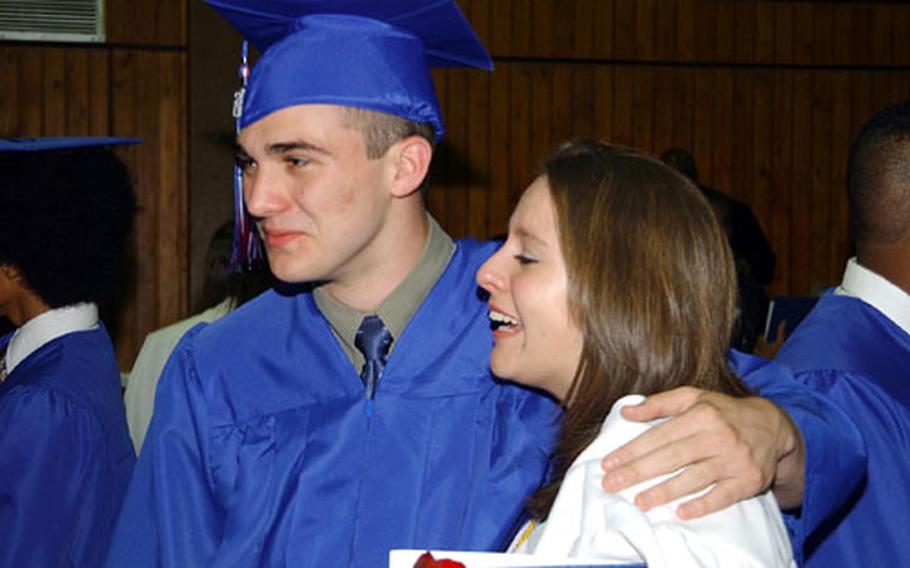 Ramstein High School graduates Kelly Kanapaux, left, and Anne Marie Marchand, right, embrace after graduation Friday at Kaiserslautern&#39;s Barbarossahalle in Germany.