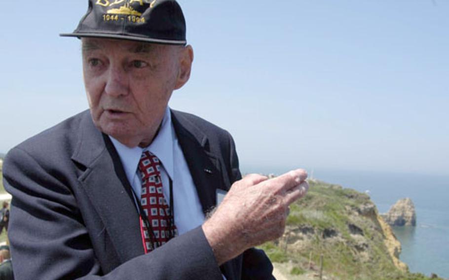 With the Pointe du Hoc in the background, John Reville, a 2nd U.S. Ranger Battalion veteran, talks about the fighting at Pointe du Hoc on D-Day.