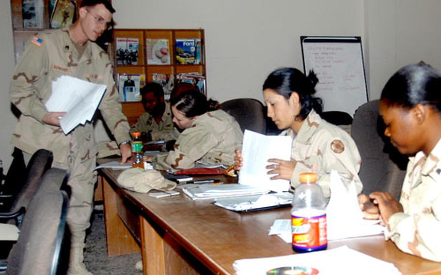 Staff Sgt. Thomas Barnhart, of the 302nd Cargo Transfer Company, tutors students in English composition.