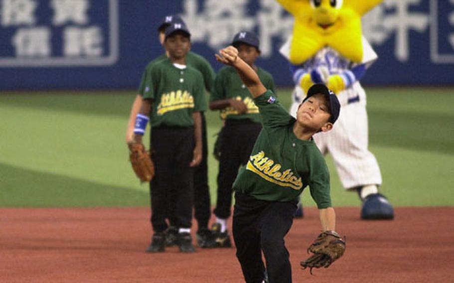 Negishi Athletics third baseman Josh Song throws back the ball he caught at Yokohama Stadium while the Yokohama Bay Star mascot and teammates watch.