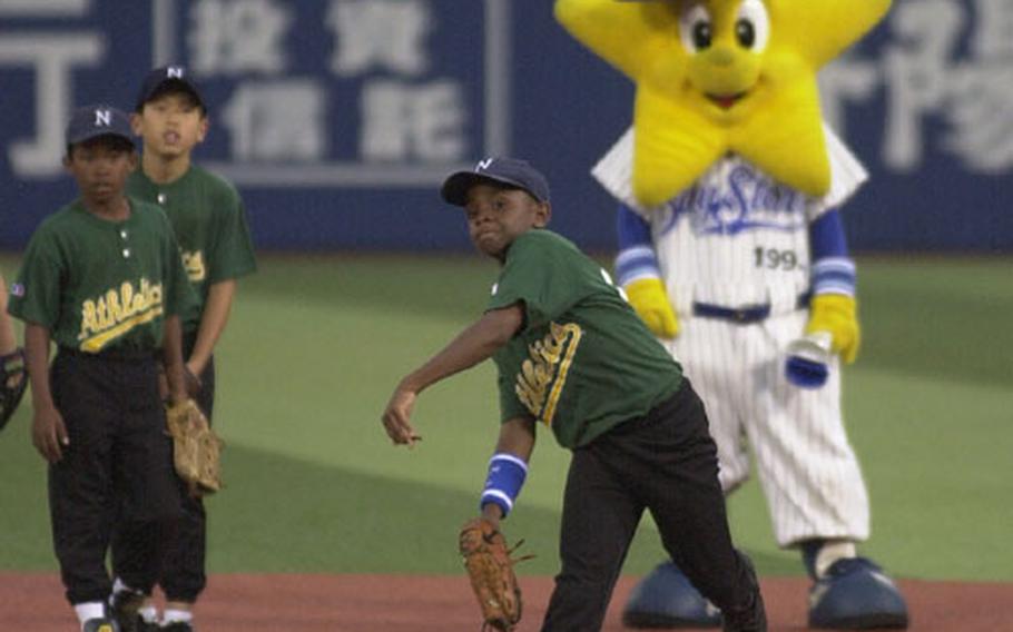 Negishi pitcher Alphonso Chapman (center) throws back the baseball he fielded at Yokohama Stadium while his teammates (from left) shortstop Shareef Hicks and third baseman Josh Song watch and wait for their turn.