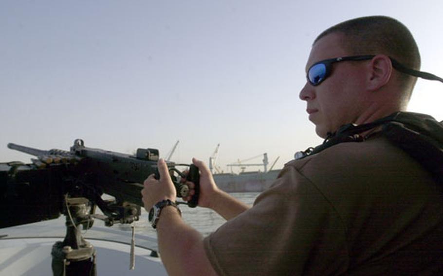 U.S. Coast Guard Petty Officer 3rd Class Robert Peterson, a reservist from Clearwater, Fla., mans the M2 .50-caliber machine gun aboard a patrol boat.