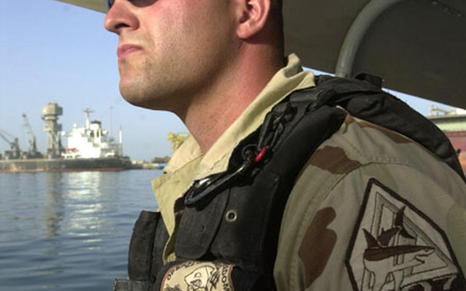 Petty Officer 3rd Class Brian Rockowitz pilots his U.S. Coast Guard patrol boat in Kuwait&#39;s Ash Shu&#39;aybah port.
