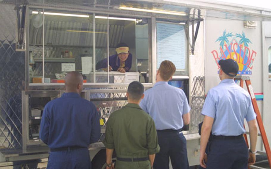 Masako Suda, operator of the Naval Air Facility Atsugi’s Navy Exchange Mobile Canteen, awaits orders from Aircraft Intermediate Maintenance Department, Atsugi sailors. The Mobile Canteen travels around Atsugi offering a variety of meals and snacks to the base community. (pnw# 61p cs)