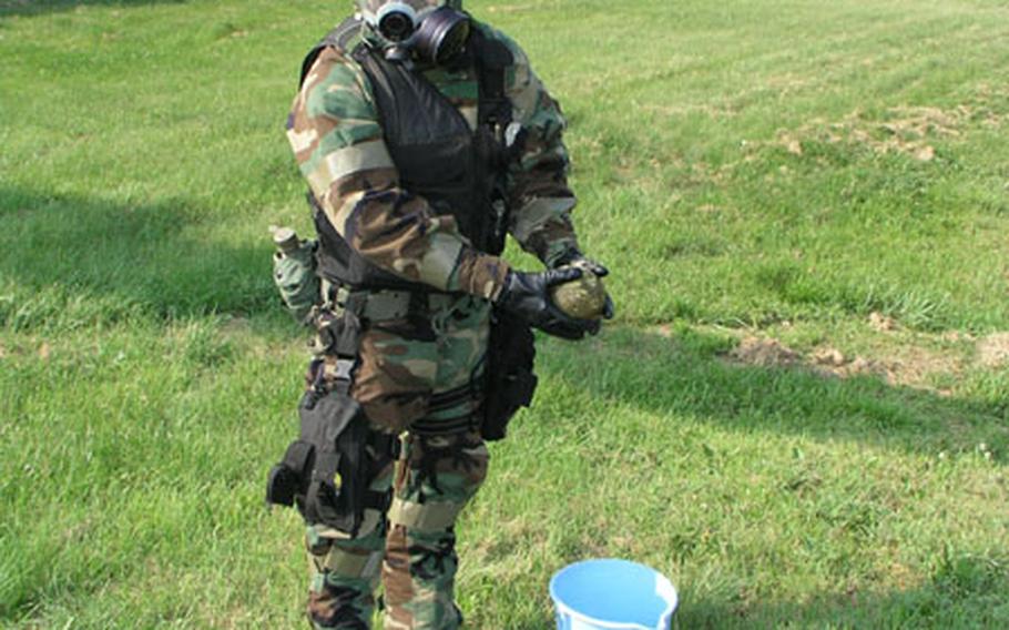 During explosive ordnance disposal training at Osan Air Base, South Korea, Senior Airman Michael Fink holds a simulated, Soviet-style chemical bomblet Wednesday during a delicate stage of the removal process.