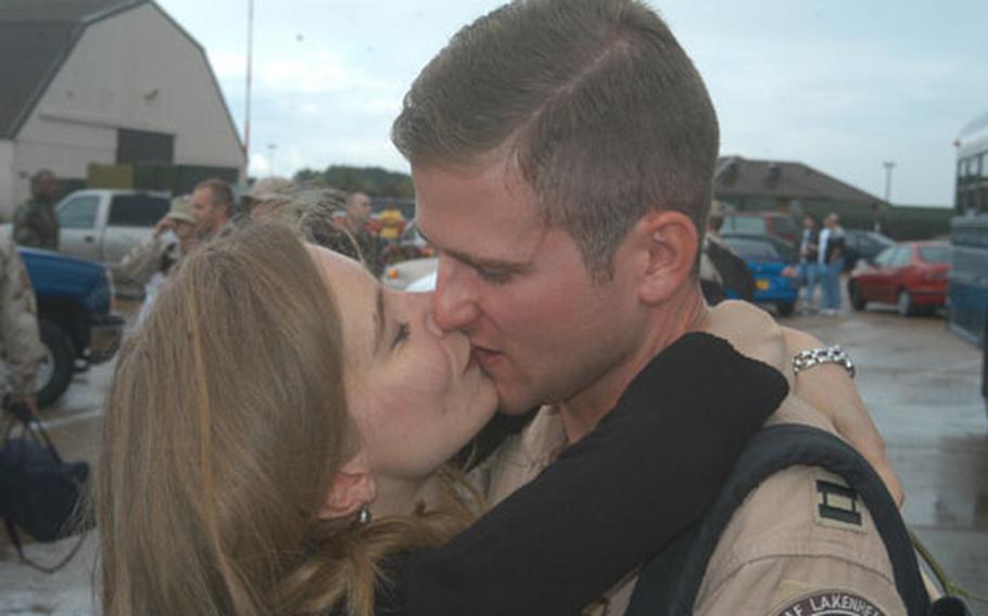 Capt. Jason Colborn receives a welcoming kiss from his wife, Erica, after returning Saturday to RAF Lakenheath, England, after three months in the Middle East. More than 200 members of the 48th Fighter Wing returned from the deployment on a rainy weekend.