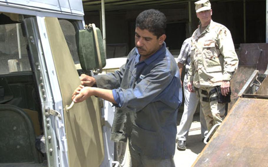 Master Sgt. Dennis Lichtenberg is always tweaking Lick Kit designs with assistance from an Iraqi steel fabricator on the grounds of the Green Zone. A worker fits a new door — with angled steel plates on the exterior — on a Humvee.