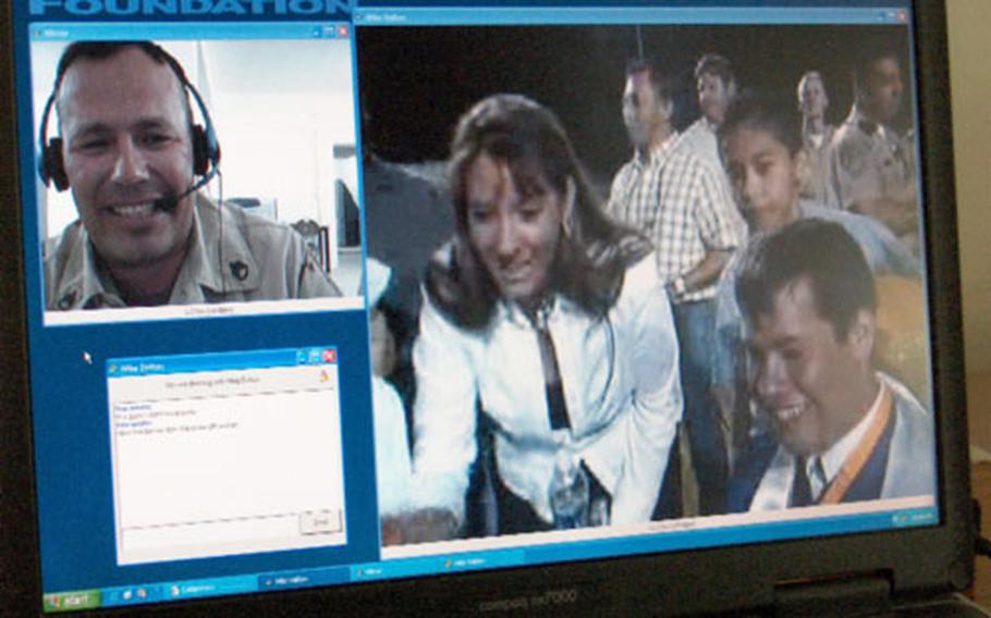 Staff Sgt. Jacques Rodriguez, with Company A, 185th Corps Support Command, upper left, talks to his family in California using new high-speed video teleconference equipment available at Camp Cooke, Iraq. Rodriguez&#39;s son, Joshua, graduated from Southwest High School on Friday night.