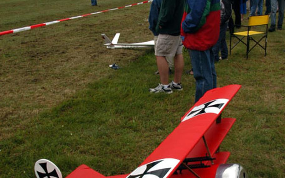 Spectators watch air demonstrations as a Fokker D-3 tri-plane model sits in the foreground at the 50th anniversary air show at the Mont Royal Airfield Saturday near Traben-Trarbach, Germany.
