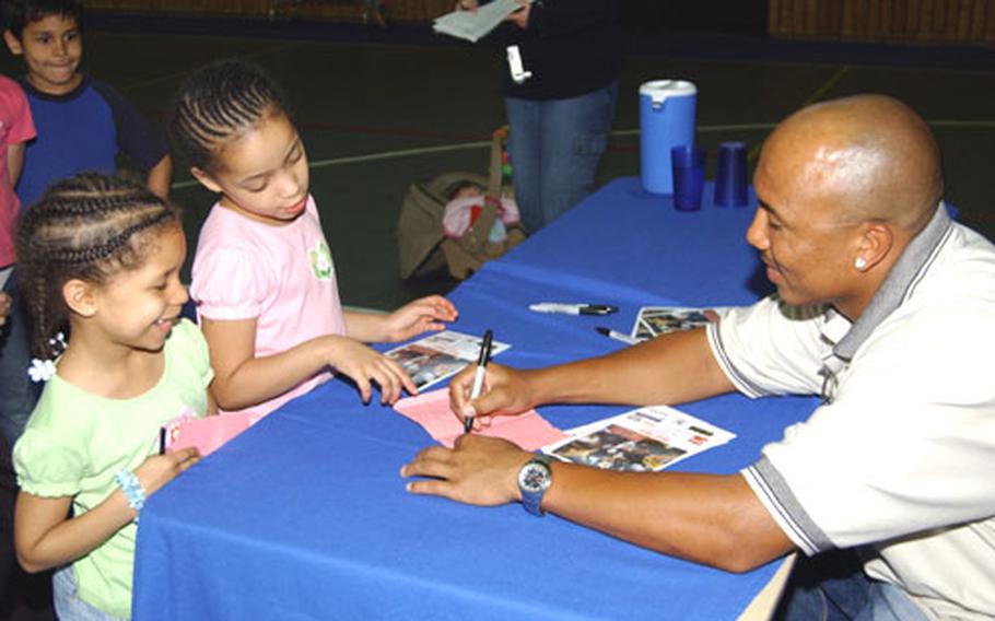 Pittsburgh Steeler Hines Ward signs autographs for Tianna Haning, left, and Ashante Johnson, both 6, at the Gateway Gardens’ Youth Center on Monday. As part of his 10-day tour as an Extreme Summer speaker, Ward visited the youth center, the Rhein-Main base exchange and passenger terminal.