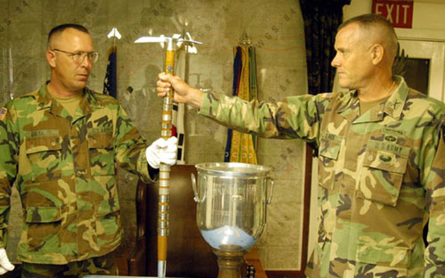 Staff Sgt. Ricky Bryant, left, of the 2nd Infantry Division Museum, receives Hitler&#39;s walking stick and the Sink Grail from 1-506th commander Col. David Clark at Camp Greaves on Thursday. Units headed to Iraq are storing many of their trophies and unit symbols until their return.