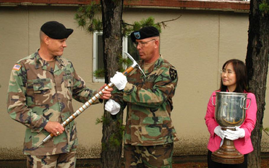 Staff Sgt. Ricky Bryant, of the 2nd Infantry Division Museum, receives Hitler&#39;s walking stick and the Sink Grail from 1-506 Commander Col. David Clark, left, at Camp Greaves on Thursday while museum technician Incha Koslosky looks on, holding a cup made from other World War II memorabilia.