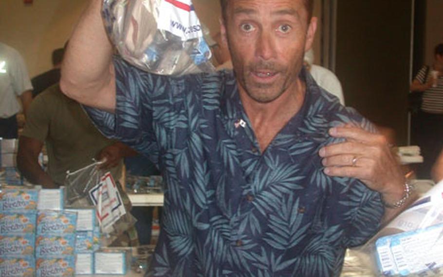 Musician Lee Greenwood, famous for his hit "God Bless the USA," helps the USO stuff care packages Thursday at Fort Myer, Va. The 3,000 goodie bags are destined for U.S. servicemembers in Iraq.