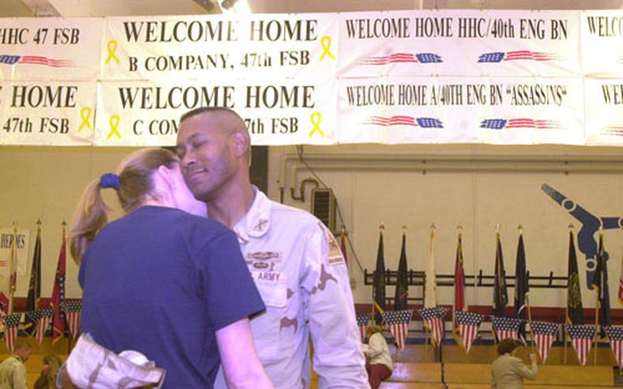 Just home after 15 months in Iraq, Capt. Walter Dunn dances an impromptu slow dance with his wife, Eden, in Baumholder&#39;s gym.