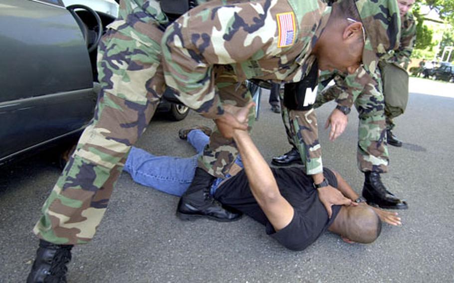 Spc. Tyrerse Dean, front, from the 88th Military Police wrestles Capt. Moises Ramirez, the Anti-Terrorism Officer to the ground during an anti-terrorism scenario at Camp Zama.