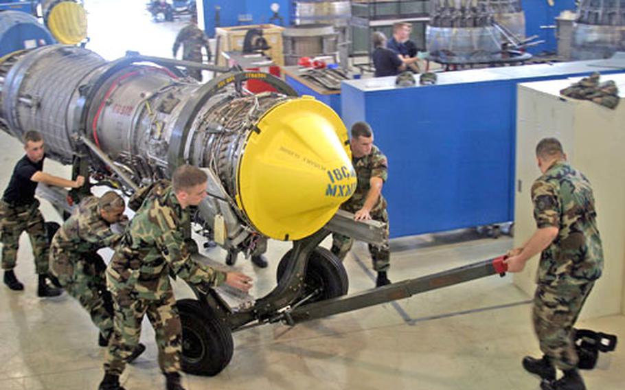 Jet engine mechanics with the 18th Component Maintenance Squadron move the last upgraded F-15 engine, ending a six-year program that saved the Air Forc an estimated $100 million. More than 100 engines were upgraded by field mechanics at Kadena Air Base instead of being sent to a maintenance depot.