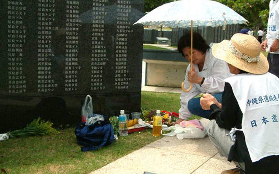 The Irime family from Naha make an offering at the stone that contains the names of three brothers killed in the Battle of Okinawa. More than 10,000 people attended a ceremony for the 59th anniversary of the Battle of Okinawa.