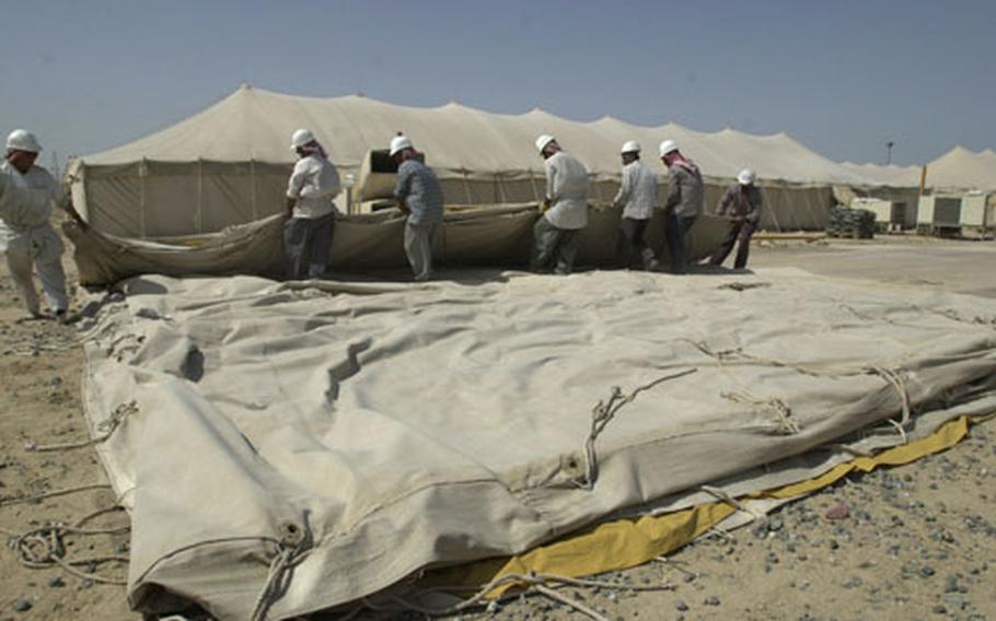 Local Kuwaiti workers fold up a 60-person tent at Camp Wolverine on Tuesday. The camp, which was the Aerial Port of Debarkation, is set to close in several weeks. All APOD operations have moved to Camp Doha, Kuwait.