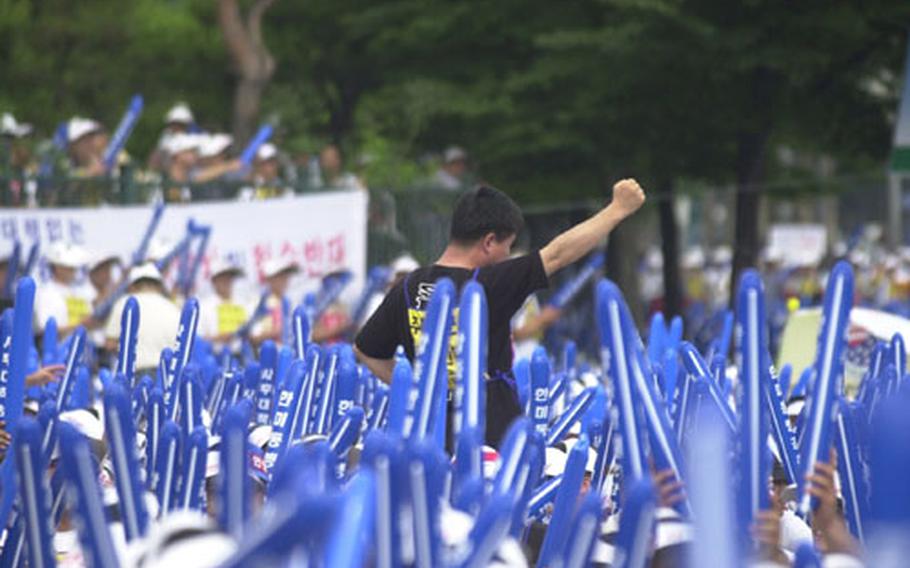 A unionized employee leads chants during a rally by thousands of Korean workers who fear job cuts at U.S. bases in South Korea.