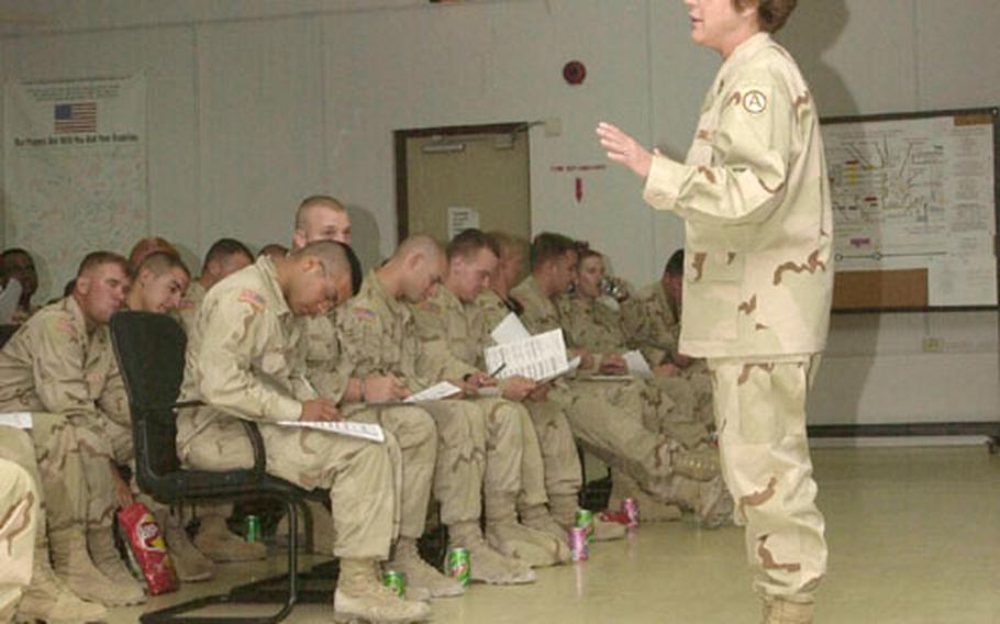 Army Master Sgt. Ellie Walbridge briefs troops just arriving in Qatar for the beginning of their four-day Fighter Management Pass. Walbridge is the program&#39;s Morale, Welfare and Recreation supervisor.